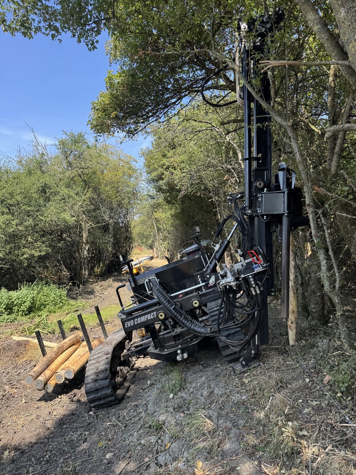 Tracked post driver working beside woodland